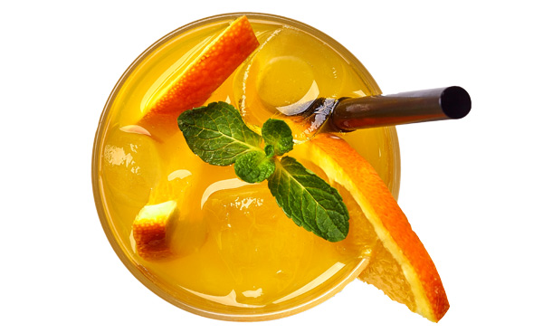 gelber Cocktail in Draufsicht mit Minze Orangenscheiben und Strohhalm