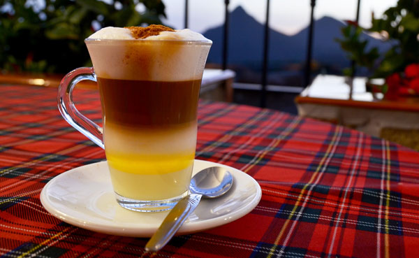 Glas mit verschiedenen geschichteten Flüssigkeiten: Kaffee, Eierlikör, Milchschaum usw.