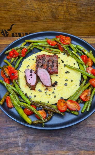 Wildschweinrücken auf Grappa-Polenta und in Butter geschwenkten Bohnen mit Tomaten